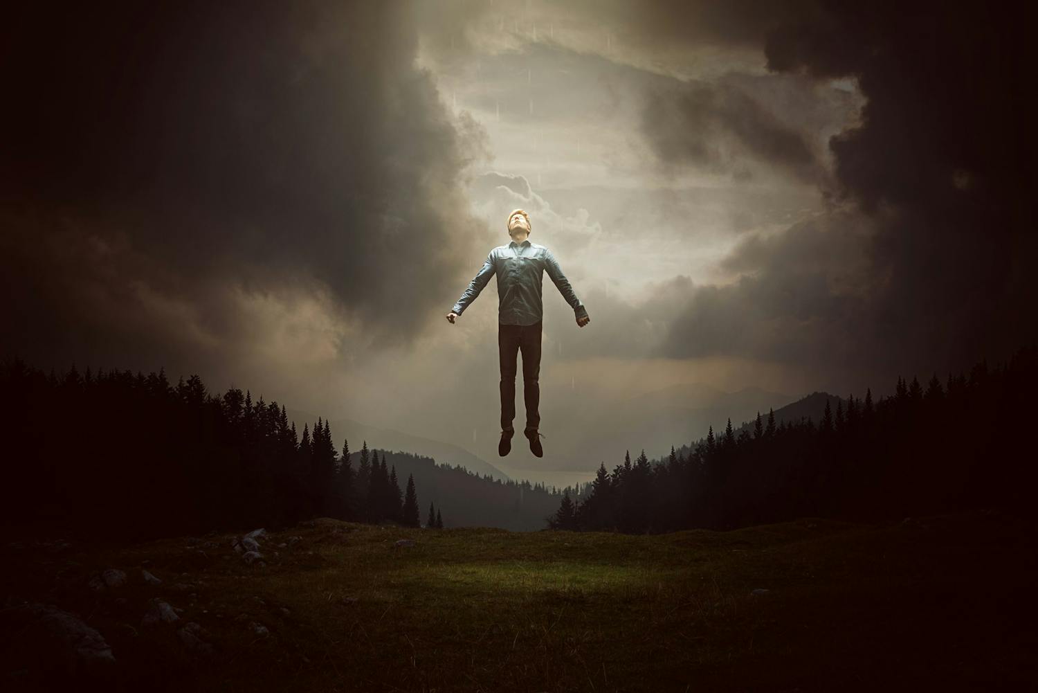 Mies kelluu ilmassa maiseman yllä